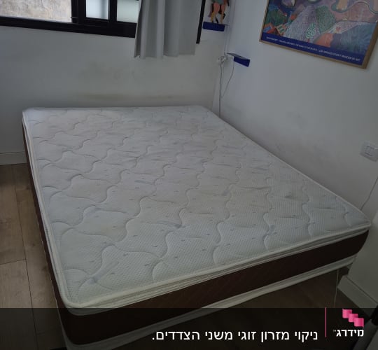 מזרן על רצפת עץ עם צינור ניקוי לידו